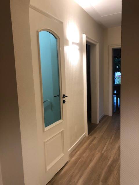 Mise en valeur d’un intérieur avec porte vitrée en verre ultra gris Saint-Gobain, conjuguant élégance, modernité et savoir-faire artisanal