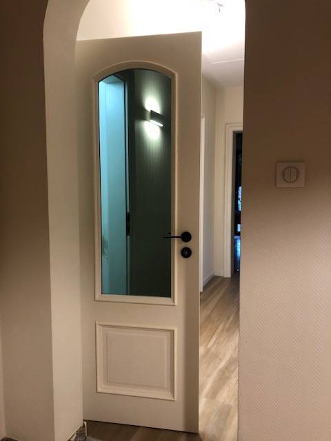 Mise en valeur d’un intérieur avec porte vitrée en verre ultra gris Saint-Gobain, conjuguant élégance, modernité et savoir-faire artisanal